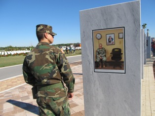 soldier dressed in uniform reading a sign at the wreath laying ceremony